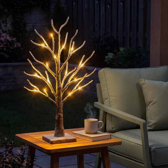 Verschneiter Tischbaum mit Licht – funkelnde Lichter auf bereiften Zweigen